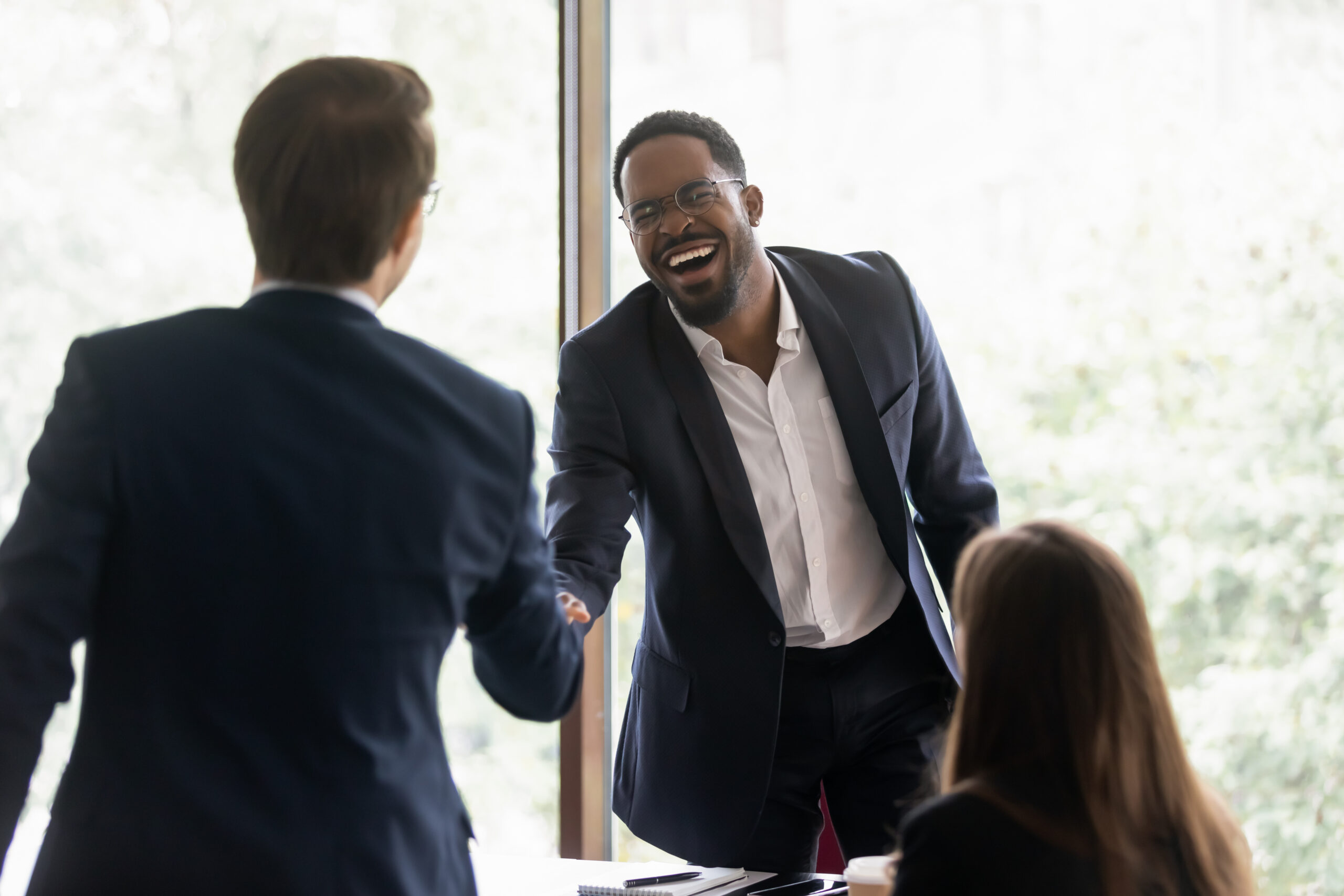 Happy diverse business leader and client shaking hands on meeting. Confident lawyer, bank employee, broker giving handshake to investor, partner. Employer hiring job candidate after interview
