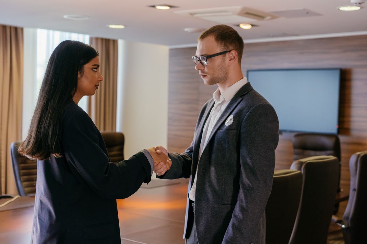 Commercial lease negotiation — two professionals reaching agreement in a conference room